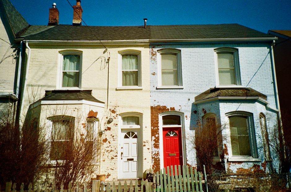 Colonial-style brick houses in Toronto with rustic charm, featuring distinct red and white doors.